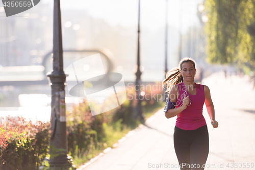 Image of woman jogging at sunny morning