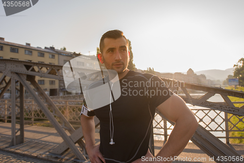 Image of portrait of a jogging man at sunny morning