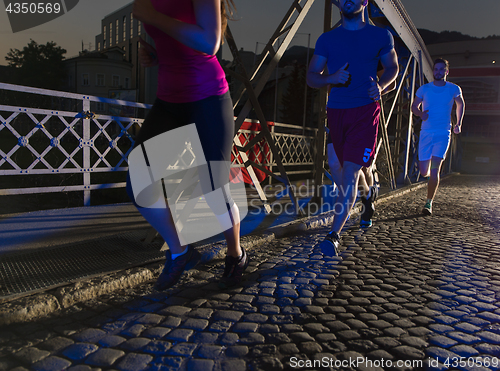 Image of young people jogging across the bridge