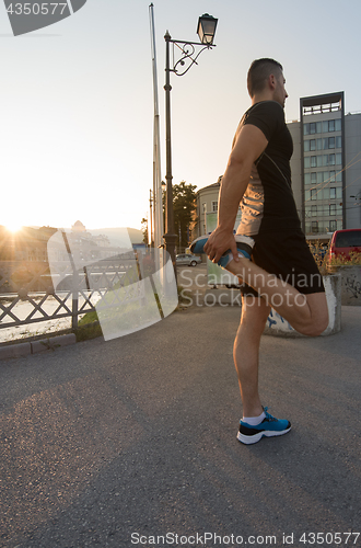 Image of athlete man warming up and stretching