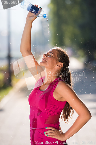 Image of woman pouring water from bottle on her head