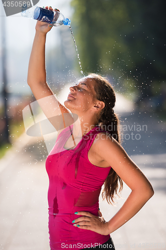 Image of woman pouring water from bottle on her head