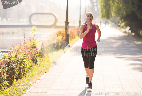 Image of woman jogging at sunny morning