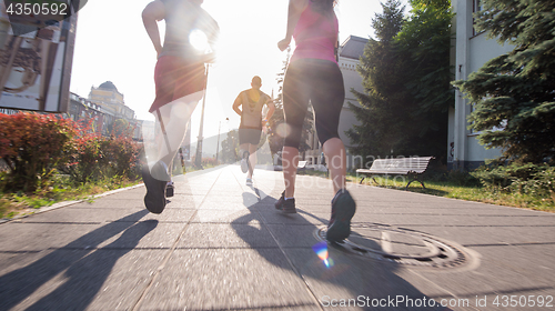 Image of group of young people jogging in the city