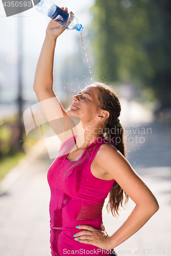 Image of woman pouring water from bottle on her head