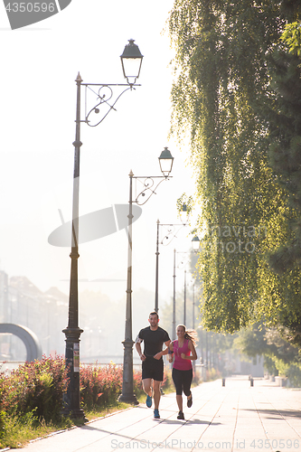 Image of young couple jogging  in the city