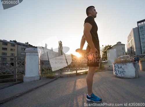 Image of athlete man warming up and stretching