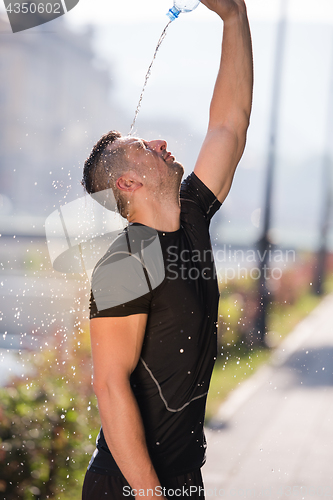 Image of man pouring water from bottle on his head