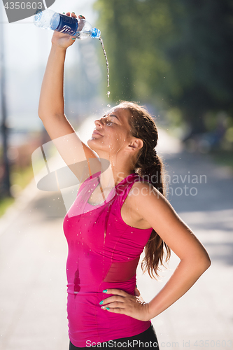 Image of woman pouring water from bottle on her head