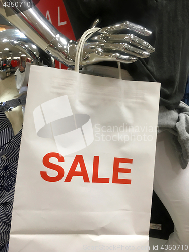 Image of Mannequin holing a sale shopping bag