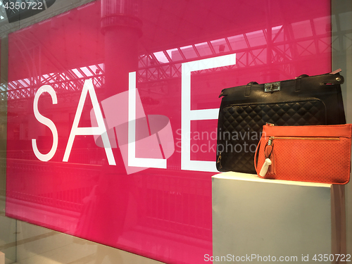 Image of Sale Sign and handbags on display in shop front window
