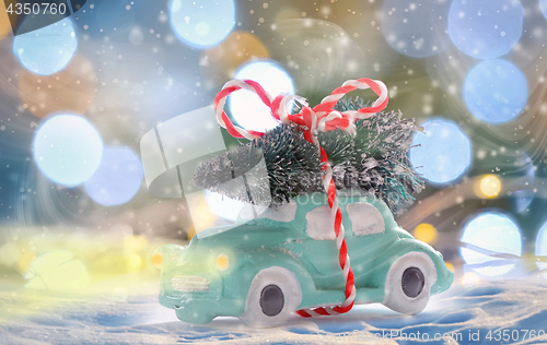 Image of toy car carrying a Christmas tree