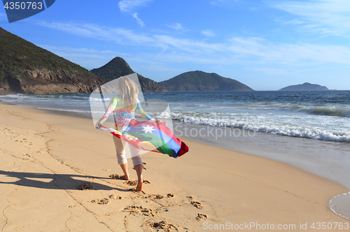 Image of Woman runs along the beach with an Australian Flag