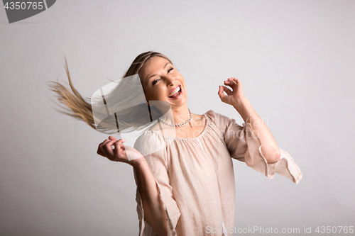 Image of Smiling carefree natural  spirited woman flicking long hair