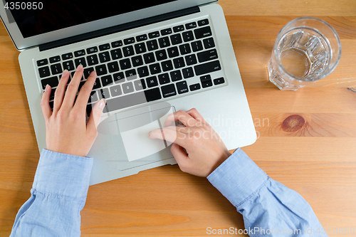 Image of Top view of woman typing on laptop computer