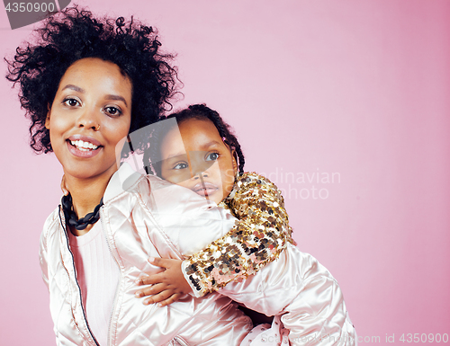 Image of young pretty african-american mother with little cute daughter hugging, happy smiling on pink background, lifestyle modern people concept 