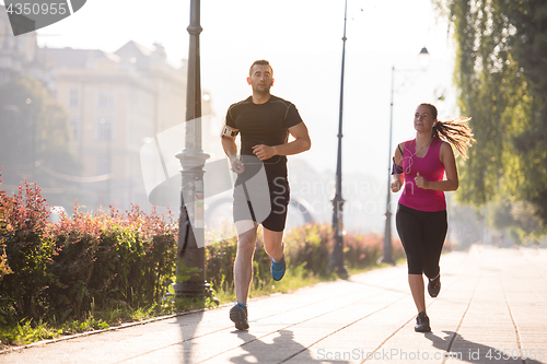 Image of young couple jogging  in the city