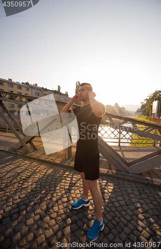 Image of portrait of a jogging man at sunny morning