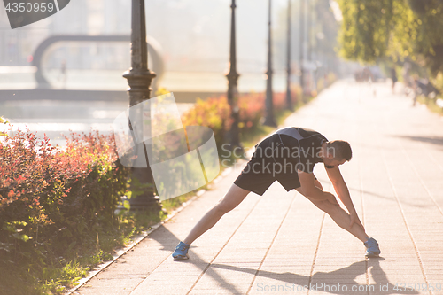 Image of athlete man warming up and stretching