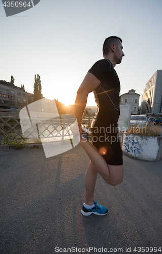 Image of athlete man warming up and stretching