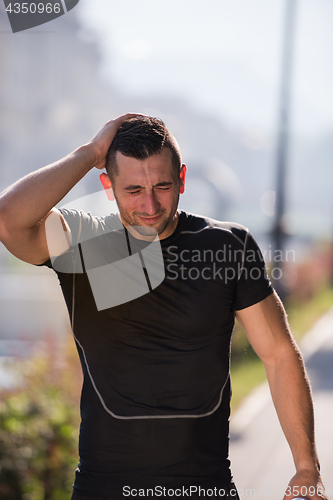 Image of man pouring water from bottle on his head