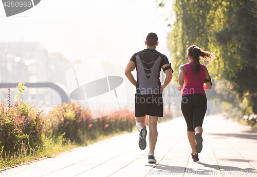 Image of young couple jogging  in the city