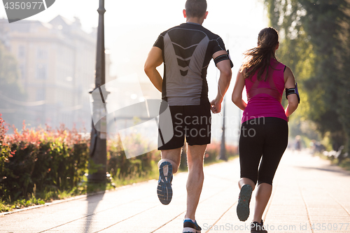 Image of young couple jogging  in the city