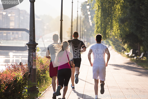 Image of group of young people jogging in the city