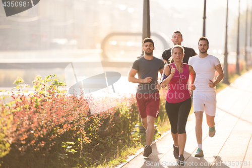 Image of group of young people jogging in the city