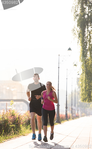 Image of young couple jogging  in the city