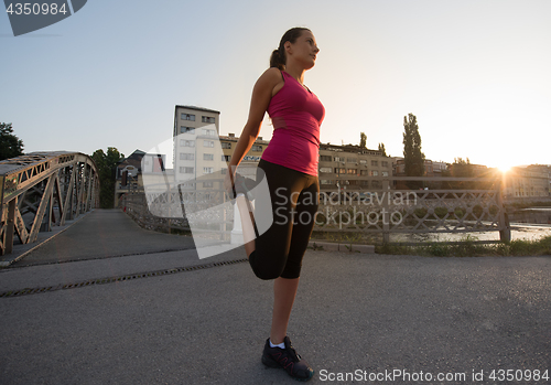 Image of athlete woman warming up and stretching