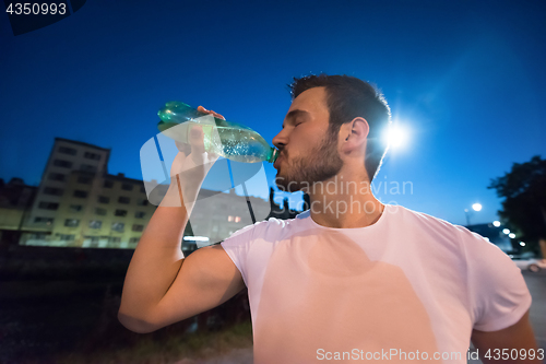 Image of man drinking water after running session