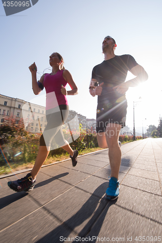 Image of young couple jogging  in the city