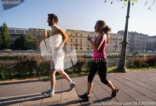 Image of young couple jogging  in the city