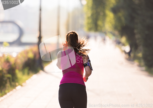 Image of woman jogging at sunny morning