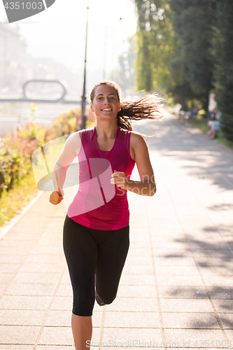 Image of woman jogging at sunny morning