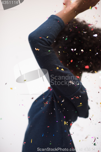 Image of African American woman blowing confetti in the air