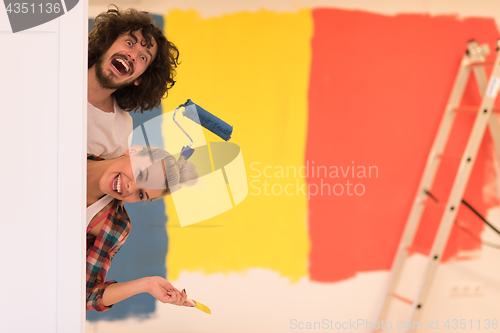 Image of portrait of a couple painting interior wall