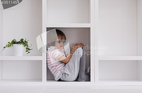 Image of young boy posing on a shelf