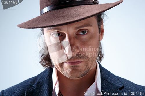 Image of Young man portrait with hat on gray studio background.