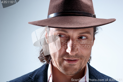 Image of Young man portrait with hat on gray studio background.