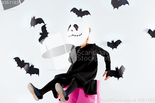 Image of Little girl witch in black dress over magical accessories. Halloween, the studio evening.