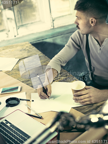 Image of Architect working on drawing table in office