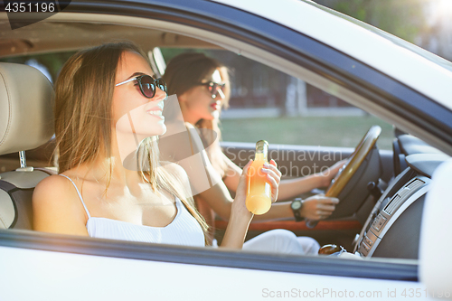 Image of The young women in the car smiling