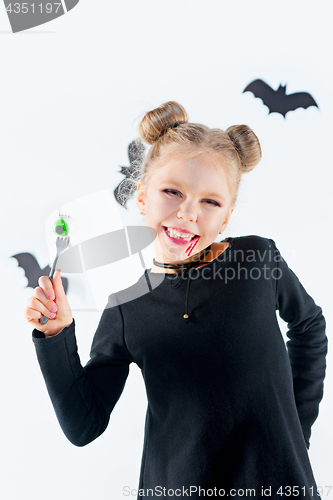 Image of Little girl witch in black dress over magical accessories. Halloween, the studio evening.