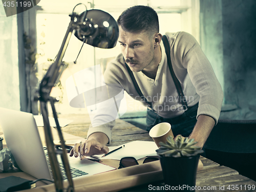 Image of Architect working on drawing table in office