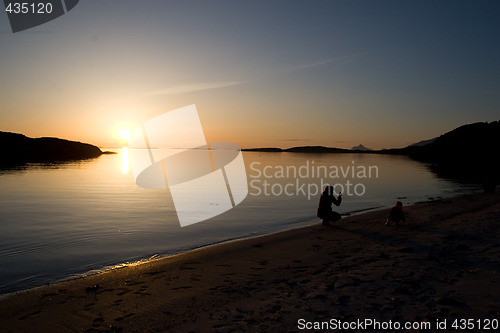 Image of Mother photographing her child at the beach