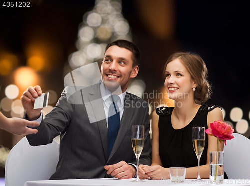 Image of couple with credit card at christmas restaurant