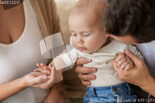 Image of close up of happy family with baby at home