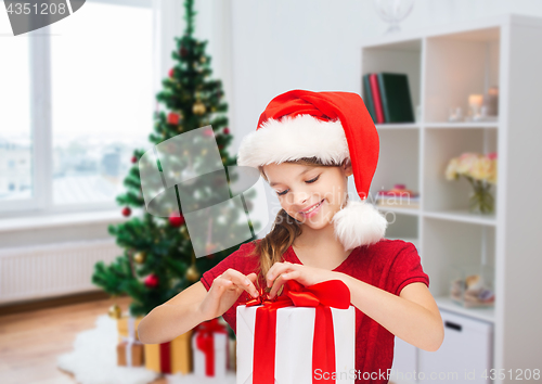 Image of smiling girl in santa hat with christmas gift